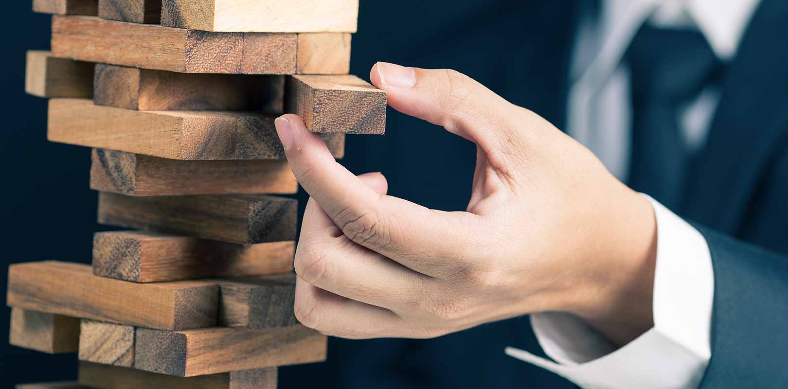 A businessman with Jenga blocks to signify risk